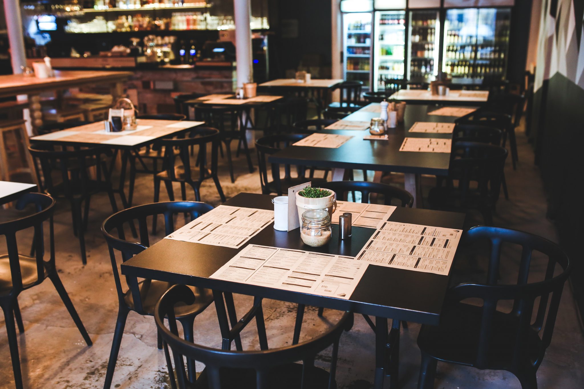 Wnętrze kawiarni ze stolikami i kartą menu na blacie